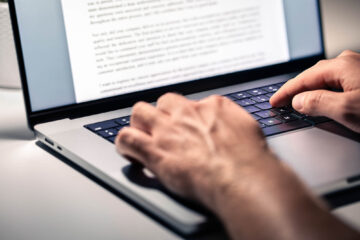 close-up of writer typing a blog using keywords and natural language